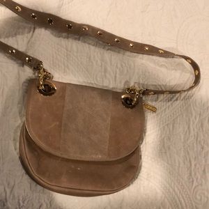 Tan leather bag with red soft material inside.